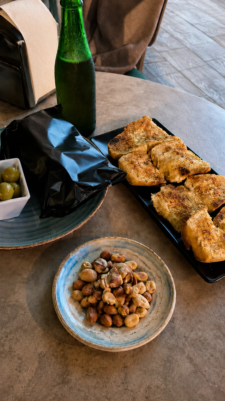 Cerveza fría con aceitunas, frutos secos y aperitivos para compartir